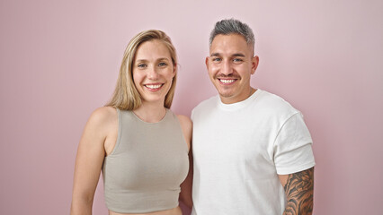 Fototapeta premium Man and woman couple standing together smiling over isolated pink background