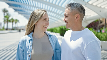 Obraz premium Man and woman couple looking each other standing together at park