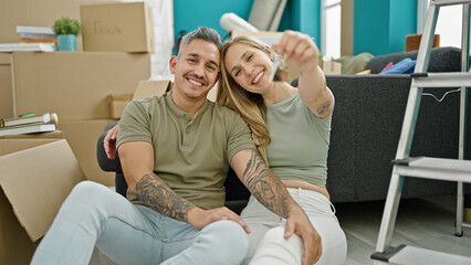 Man and woman couple hugging each other holding keys at new home