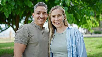 Obraz premium Man and woman couple smiling confident standing together at park