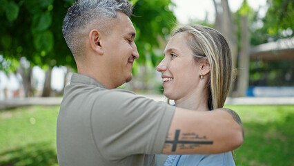 Man and woman couple hugging each other smiling at park