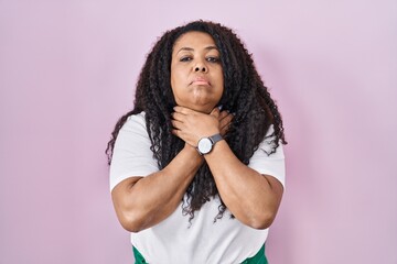 Plus size hispanic woman standing over pink background shouting suffocate because painful strangle. health problem. asphyxiate and suicide concept.