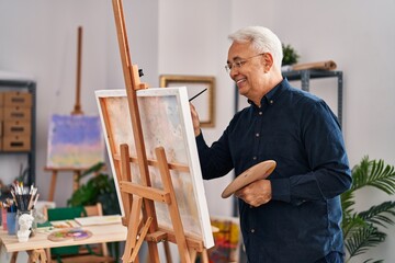 Senior man smiling confident drawing at art studio