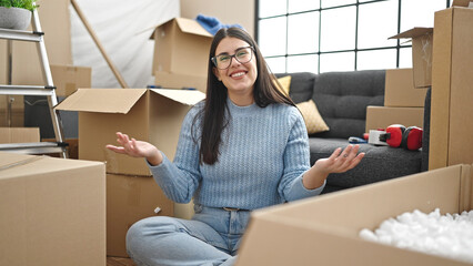 Young hispanic woman smiling with open arms at new home