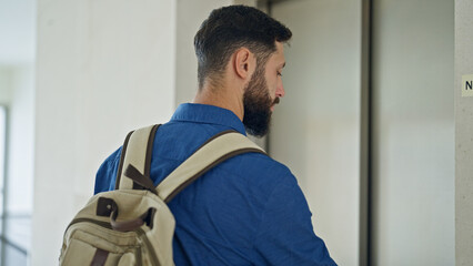 Young hispanic man business worker looking watch waiting for elevator at the office © Krakenimages.com
