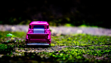 South Minahasa, Indonesia : January 2023, a toy car on a mossy floor that looks like grass