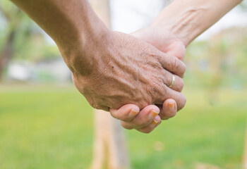 Two hands of a couple in love, people of different ages hold hands tightly