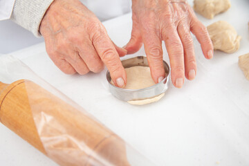 Stretching the dough to make mini pizzas. Delicious home made mini pizzas preparation.