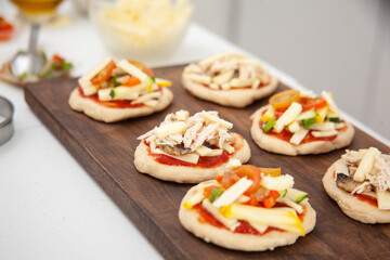 Ready to be baked mini pizzas. Delicious home made mini pizzas preparation.