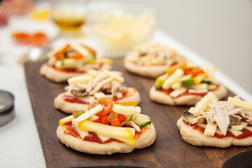 Ready to be baked mini pizzas. Delicious home made mini pizzas preparation.