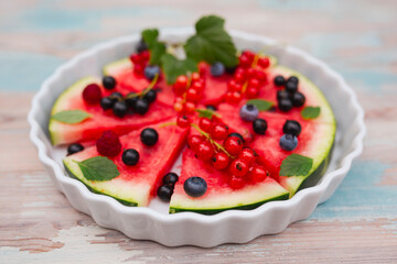 Fruity watermelon pizza with seasonal fruits on the wooden table