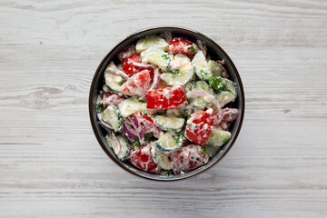 Homemade Tomato Cucumber Feta Salad in a Bowl, top view. Flat lay, overhead, from above.