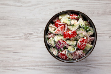Homemade Tomato Cucumber Feta Salad in a Bowl, top view. Flat lay, overhead, from above. Copy space.