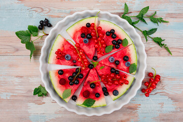 Fruity watermelon pizza with seasonal fruits on the wooden table