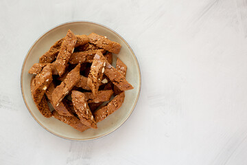 Homemade Italian Cantuccini with Almond and Coffee on a Plate on a gray surface, side view. Crispy Almond and Coffee Cookies.