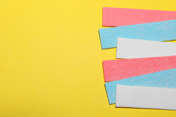 Sticks of tasty chewing gum on yellow background, flat lay. Space for text