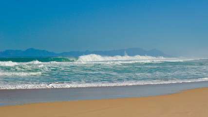  powerful cross ocean wave breaking during the day on the beach