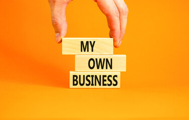 My own business symbol. Concept words My own business on wooden block. Beautiful orange table orange background. Businessman hand. Business motivational my own business concept. Copy space.