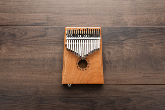 Wooden kalimba on the wooden background. Overhead photo of mbira instrument with copy space.