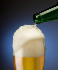 pouring beer into a mug with foam