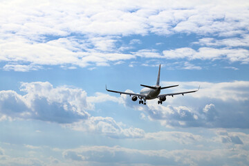 A plane from the side approaching for landing, against the background of clouds.