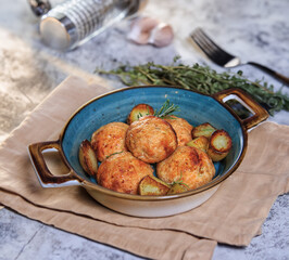 fish cakes with a sprig of rosemary on a gray table and with a beige serving napkin