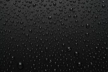 Fotobehang Gotas de agua sobre fondo negro rugoso © imstock