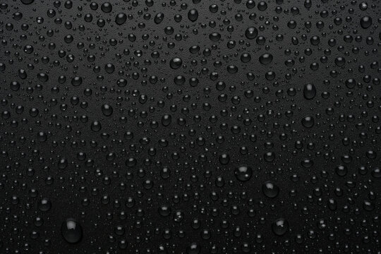 Gotas de agua sobre fondo negro rugoso