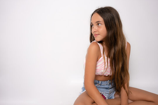 young 11 year old girl sit on floor rest with a smile into camera with copy space isolated on white