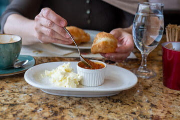 Woman having fresh, domestic fritters with salty and sweet spreads in a restaurant