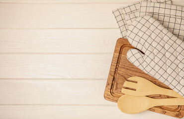 Wooden kitchen utensils, cutting board, potholder and glove on the table, top view. Kitchen Mitten...