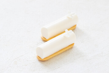 Vegan dessert. Vanilla cream cake bar, decorated with a small white flower. On cookies. White background