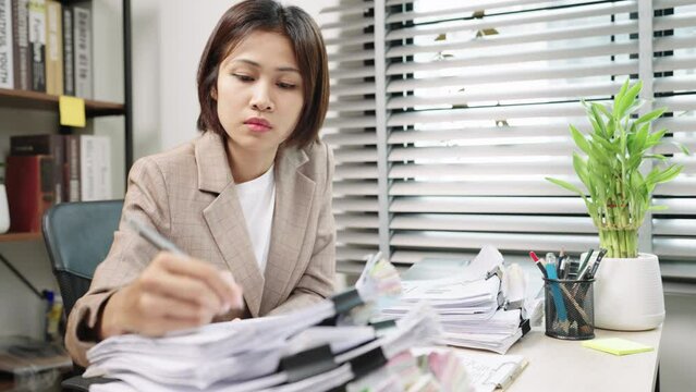 Financial analyst Asian Woman calculate Budget on Financial planning and making notes at home