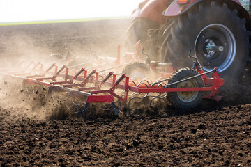 Tractor with cultivator handles field before planting.