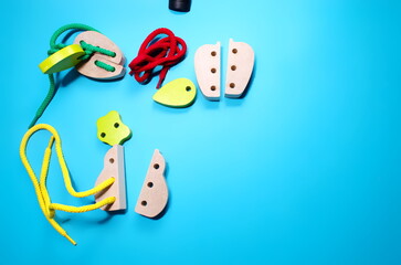 Top view closeup Colorful wooden figurines needle in tray blue background Educational toys Montessori sensorial activity for toddlers baby Hands eyes coordination Cognitive skills Children development