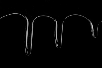 Honey flows down the surface on a black background.