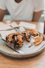 Woman is eating kind of dessert bread in the cafe.