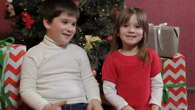 Kids share secrets near the christmas tree