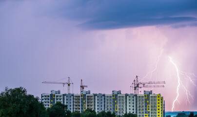 Construction of new residential buildings. In the background, a stormy sky with lightning