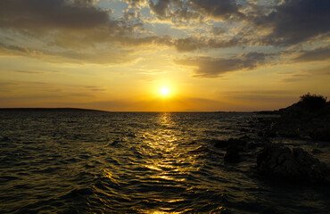 Obraz premium The rough and turbulent sea in the golden hour sunset