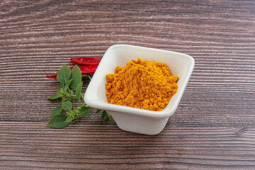 Yellow vibrant curcuma powder in the bowl