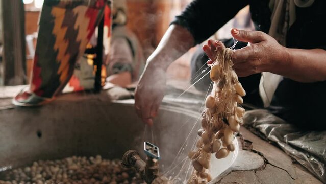 Traditional silk production. Processing Boiling silkworm cocoons in hot water. The process of producing silk by hand closeup from Cocoon to Silk thread