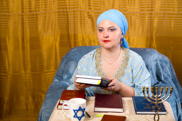 A Jewish woman in a kisui rosh headdress, a teacher of tradition, selects literature for lectures...