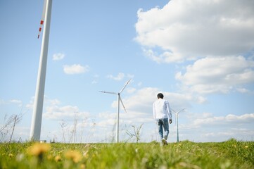 Fototapeta na wymiar Indian Engeenier standing against windmills