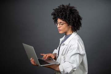 Young freelance with a laptop on grey background