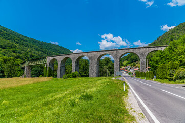 Fototapeta na wymiar A panorama view towards the railway viaduct at Bača near Modrej in Slovenia in summertime