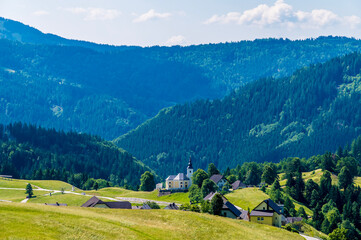 Fototapeta na wymiar A view towards the alpine village of Kranjska above lake Bohinj in Slovenia in summertime 