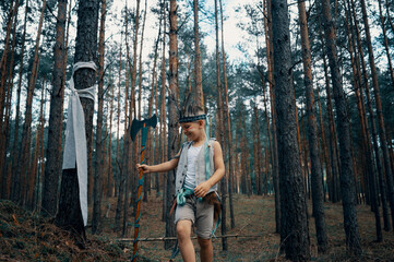 Boy dressed as an American Indian plays in the forest