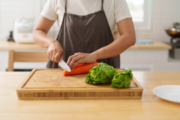 woman hand cutting up carrot preparation for cooking food