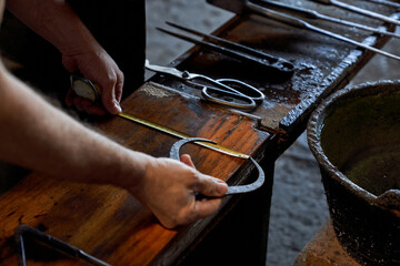 Crop artisan with measuring tape and tool in glass making factory